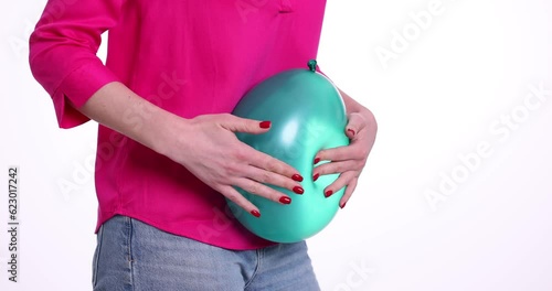 Woman is holding balloon feeling bloated. Flatulence feeling of bloating and distension of abdomen photo