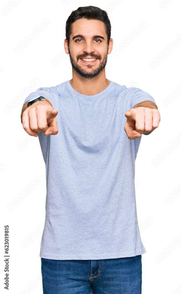 Young hispanic man wearing casual clothes pointing to you and the camera with fingers, smiling positive and cheerful