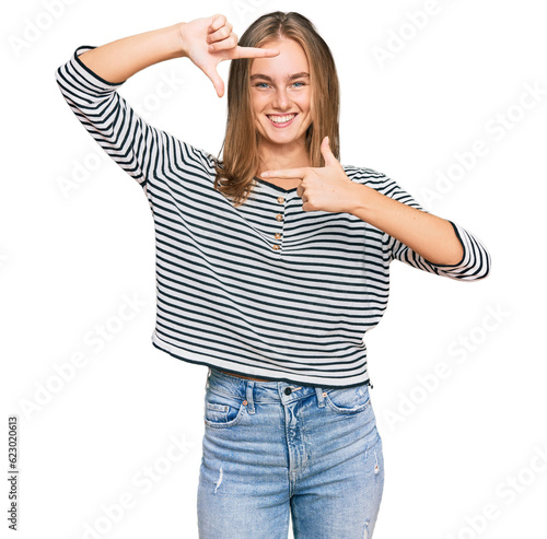 Beautiful blonde woman wearing casual clothes smiling making frame with hands and fingers with happy face. creativity and photography concept.