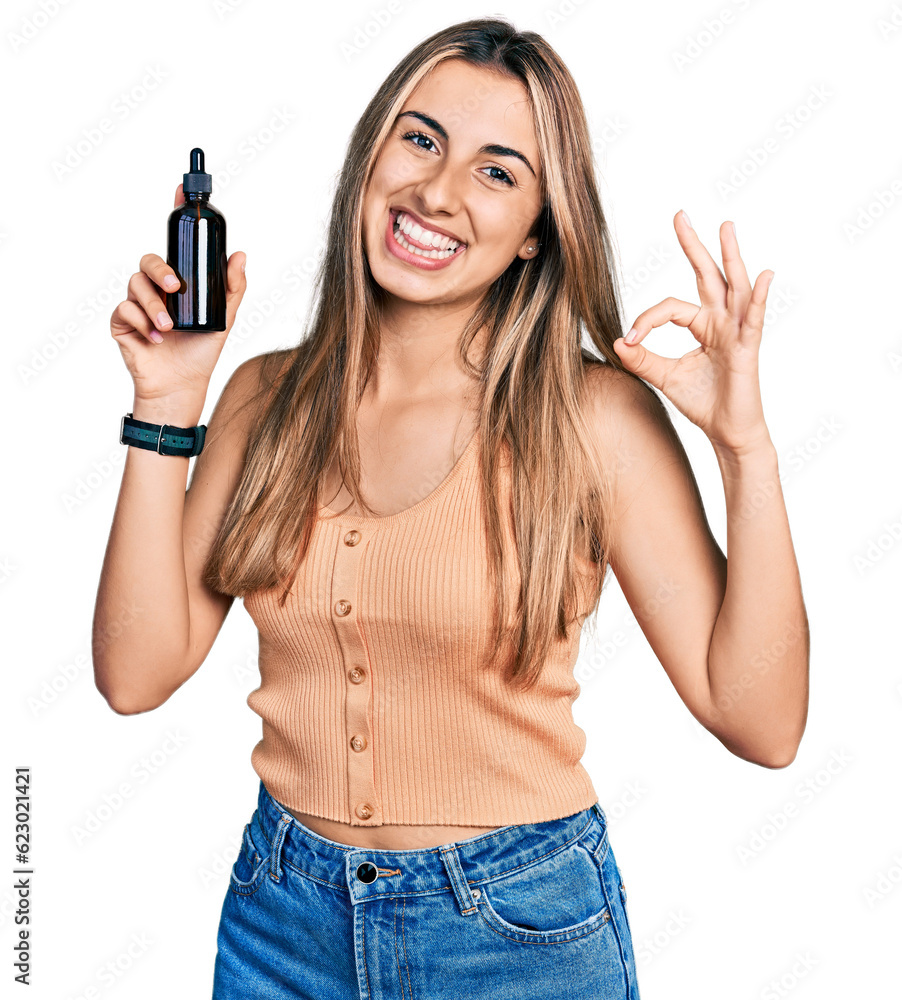 Hispanic young woman using night serum doing ok sign with fingers, smiling friendly gesturing excellent symbol Hispanic young woman using night serum doing ok sign with fingers, smiling friendly gesturing excellent symbol