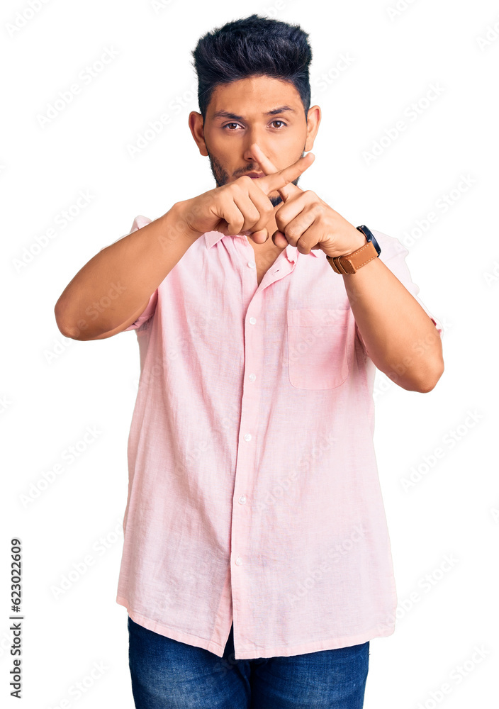 Handsome latin american young man wearing casual summer shirt rejection expression crossing fingers doing negative sign Handsome latin american young man wearing casual summer shirt rejection expression crossing fingers doing negative sign