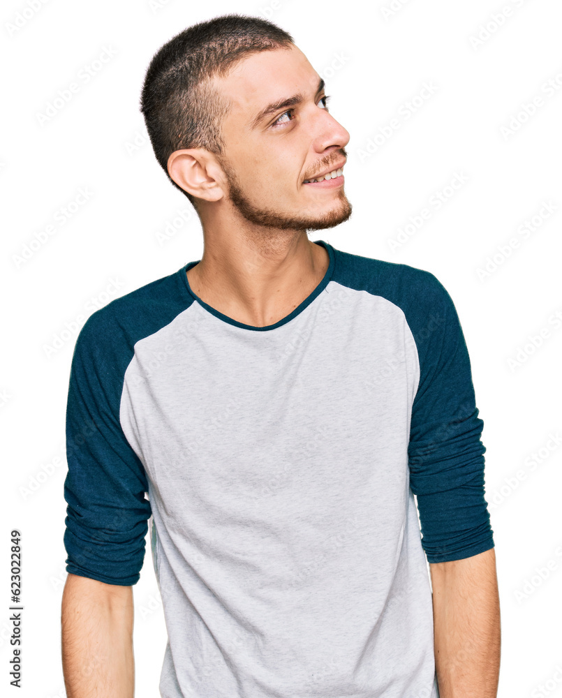 Fototapeta premium Hispanic young man wearing casual clothes looking away to side with smile on face, natural expression. laughing confident.