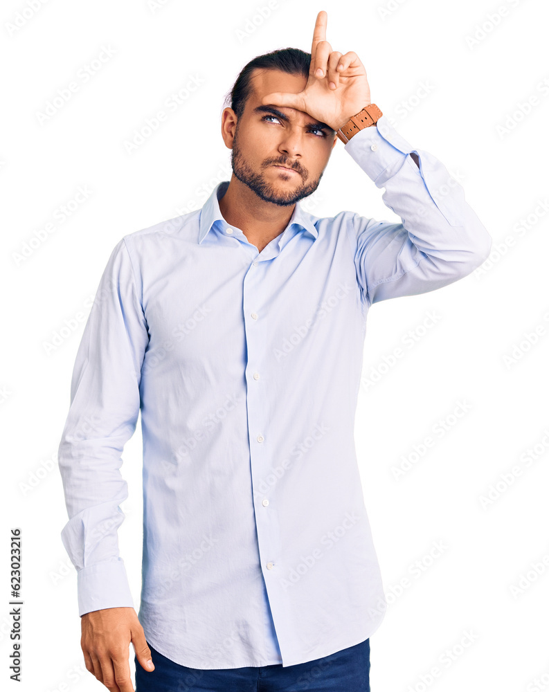 Young handsome man wearing business clothes making fun of people with fingers on forehead doing loser gesture mocking and insulting. Young handsome man wearing business clothes making fun of people with fingers on forehead doing loser gesture mocking and insulting.