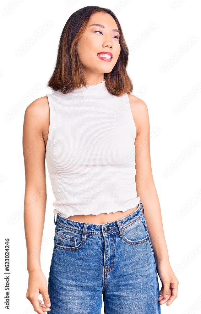 Obraz premium Young beautiful chinese girl wearing casual clothes looking away to side with smile on face, natural expression. laughing confident.