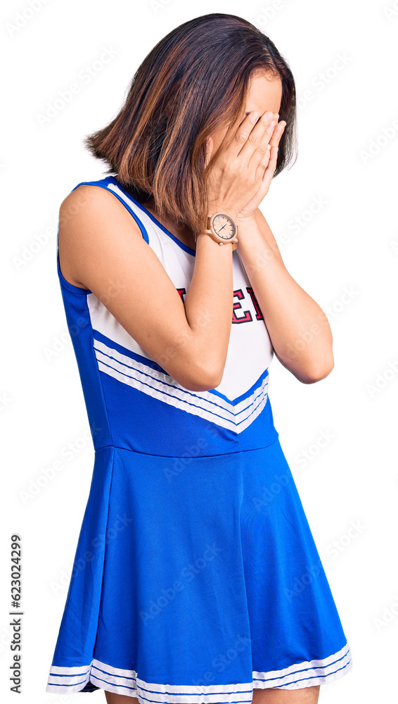 Young beautiful chinese girl wearing cheerleader uniform with sad expression covering face with hands while crying. depression concept. Young beautiful chinese girl wearing cheerleader uniform with sad expression covering face with hands while crying. depression concept.