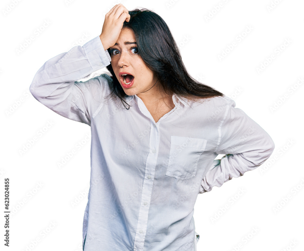 Beautiful hispanic woman wearing casual white shirt surprised with hand on head for mistake, remember error. forgot, bad memory concept. Beautiful hispanic woman wearing casual white shirt surprised with hand on head for mistake, remember error. forgot, bad memory concept.