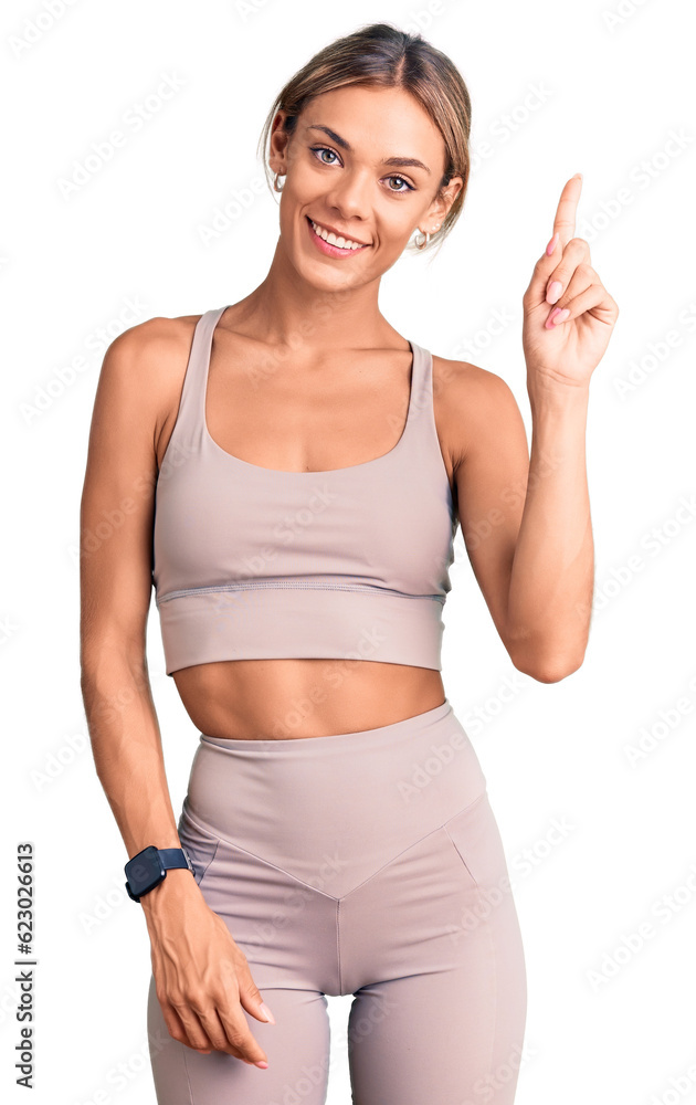 Beautiful caucasian woman wearing sportswear pointing finger up with successful idea. exited and happy. number one. Beautiful caucasian woman wearing sportswear pointing finger up with successful idea. exited and happy. number one.