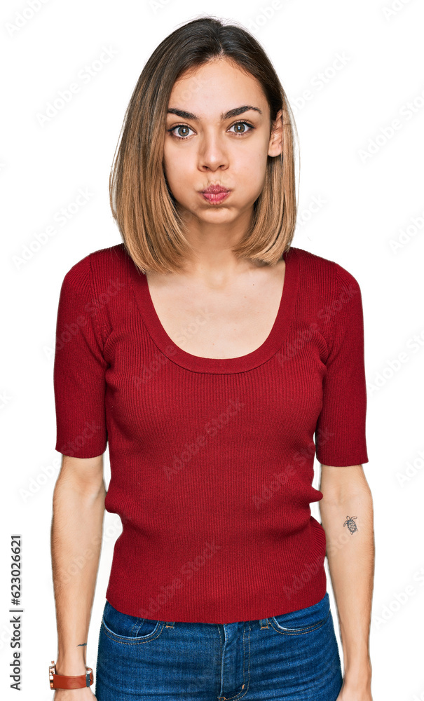 Obraz premium Young blonde girl wearing casual clothes puffing cheeks with funny face. mouth inflated with air, crazy expression.