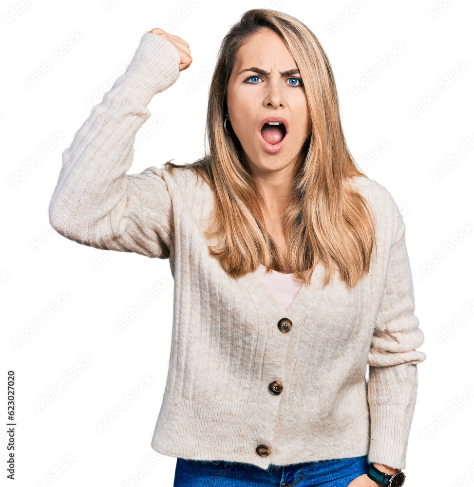Young blonde woman wearing casual clothes angry and mad raising fist frustrated and furious while shouting with anger. rage and aggressive concept. Young blonde woman wearing casual clothes angry and mad raising fist frustrated and furious while shouting with anger. rage and aggressive concept.