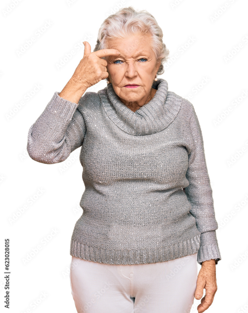 Senior grey-haired woman wearing casual winter sweater pointing unhappy to pimple on forehead, ugly infection of blackhead. acne and skin problem Senior grey-haired woman wearing casual winter sweater pointing unhappy to pimple on forehead, ugly infection of blackhead. acne and skin problem
