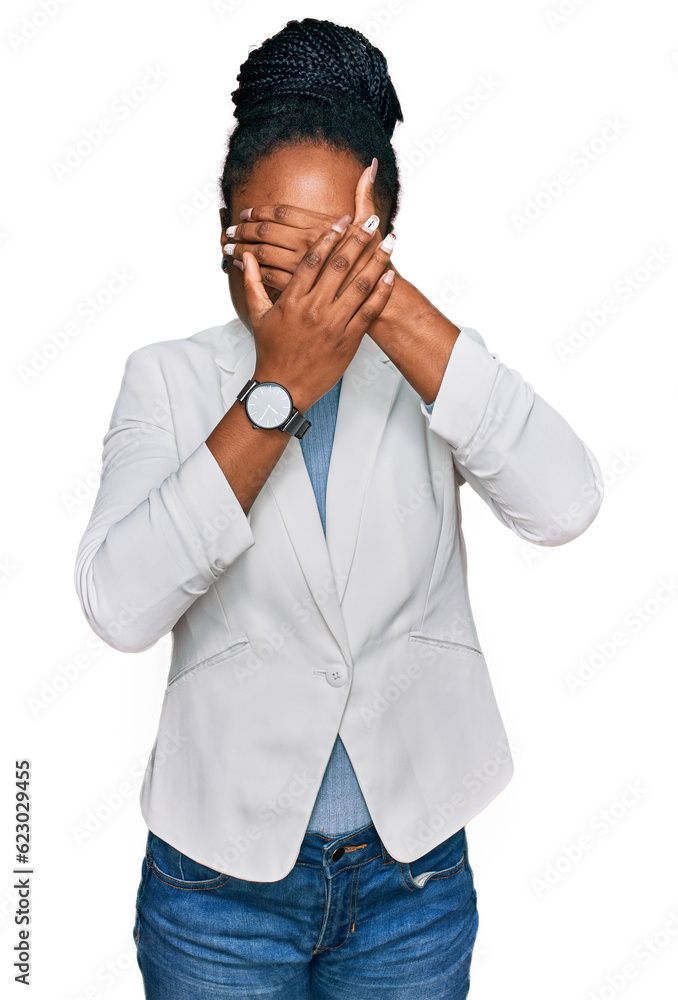 Young african american woman wearing business clothes covering eyes and mouth with hands, surprised and shocked. hiding emotion Young african american woman wearing business clothes covering eyes and mouth with hands, surprised and shocked. hiding emotion