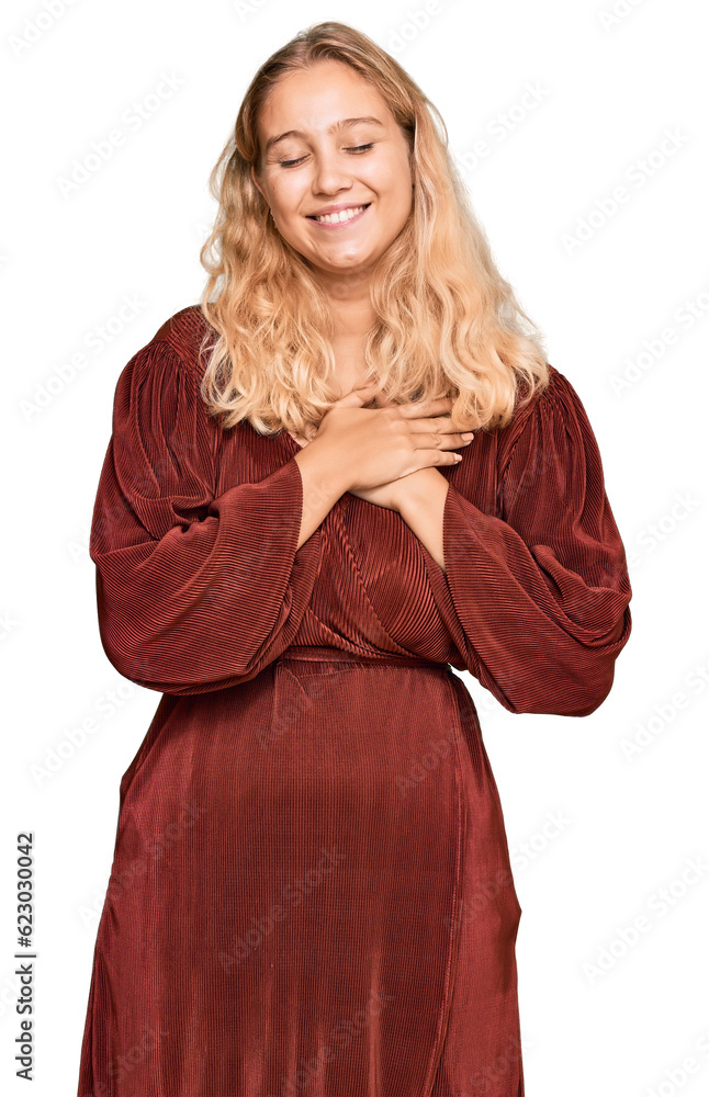 Young blonde girl wearing casual clothes smiling with hands on chest with closed eyes and grateful gesture on face. health concept. Young blonde girl wearing casual clothes smiling with hands on chest with closed eyes and grateful gesture on face. health concept.