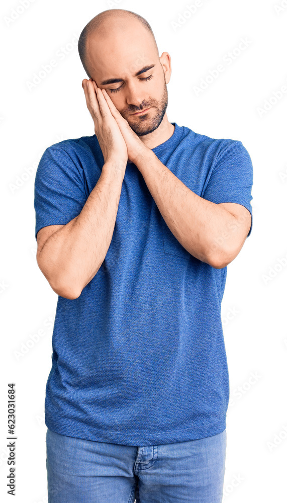 Young handsome man wearing casual t shirt sleeping tired dreaming and posing with hands together while smiling with closed eyes. Young handsome man wearing casual t shirt sleeping tired dreaming and posing with hands together while smiling with closed eyes.