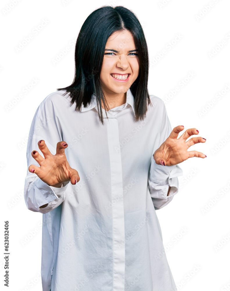 Young brunette woman with blue eyes wearing oversize white shirt smiling funny doing claw gesture as cat, aggressive and sexy expression Young brunette woman with blue eyes wearing oversize white shirt smiling funny doing claw gesture as cat, aggressive and sexy expression