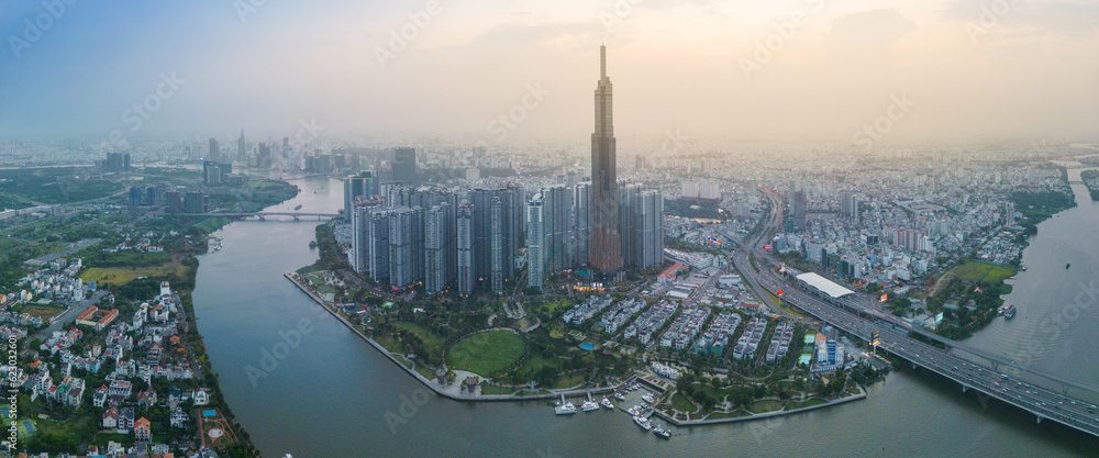Obraz premium Aerial view of a Ho Chi Minh City, Vietnam with development buildings, transportation, energy power infrastructure. Financial and business centers. Sunset to night.