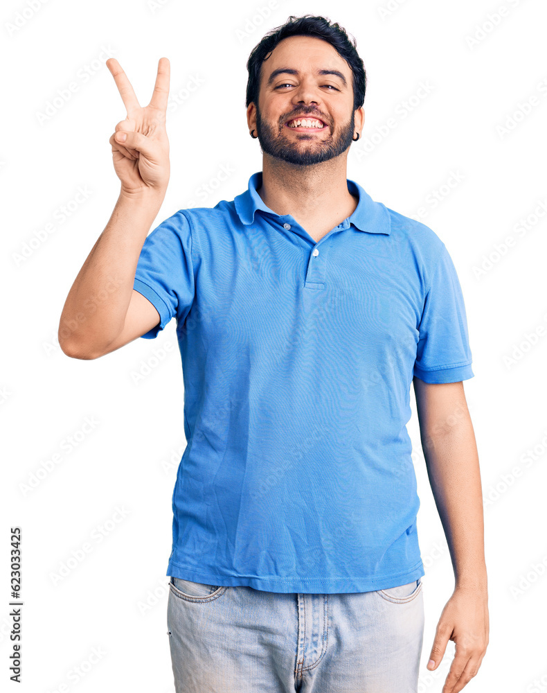 Young hispanic man wearing casual clothes showing and pointing up with fingers number two while smiling confident and happy. Young hispanic man wearing casual clothes showing and pointing up with fingers number two while smiling confident and happy.