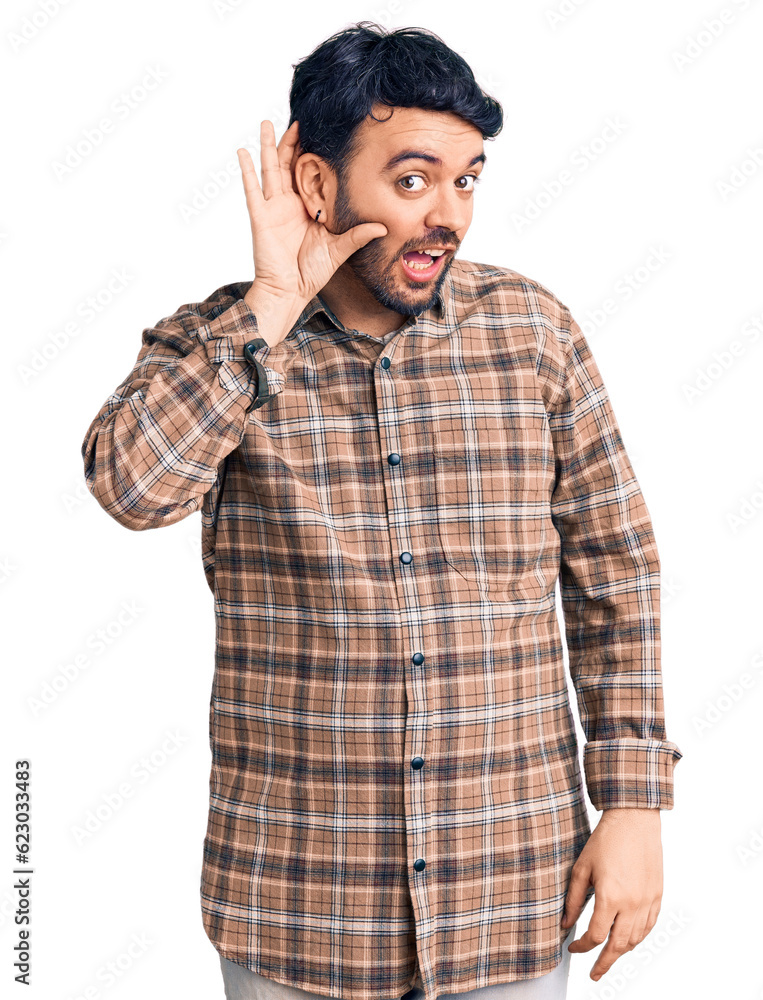 Young hispanic man wearing casual clothes smiling with hand over ear listening an hearing to rumor or gossip. deafness concept. Young hispanic man wearing casual clothes smiling with hand over ear listening an hearing to rumor or gossip. deafness concept.