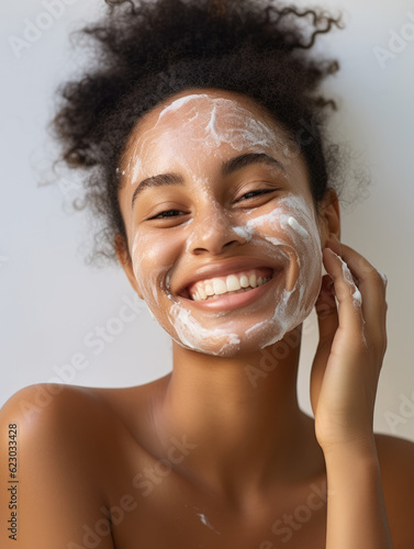 African model applying moisturizer on her face, Beauty and healthy living concept 