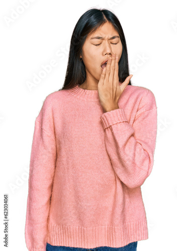 Beautiful young asian woman wearing casual winter sweater bored yawning tired covering mouth with hand. restless and sleepiness.