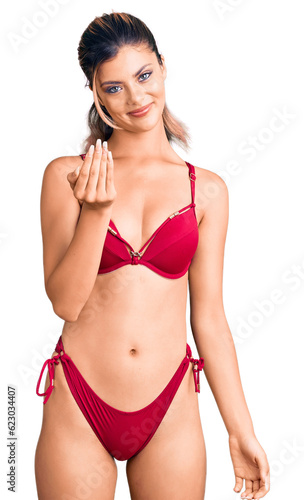 Young beautiful woman wearing bikini beckoning come here gesture with hand inviting welcoming happy and smiling © Krakenimages.com