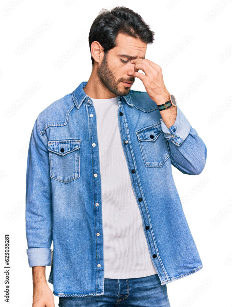 Young hispanic man wearing casual clothes tired rubbing nose and eyes feeling fatigue and headache. stress and frustration concept. Young hispanic man wearing casual clothes tired rubbing nose and eyes feeling fatigue and headache. stress and frustration concept.