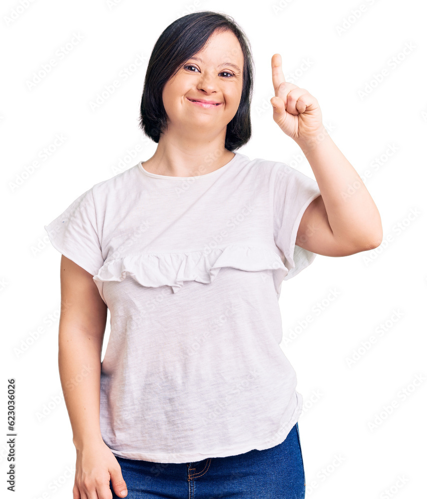 Brunette woman with down syndrome wearing casual white tshirt showing and pointing up with finger number one while smiling confident and happy. Brunette woman with down syndrome wearing casual white tshirt showing and pointing up with finger number one while smiling confident and happy.