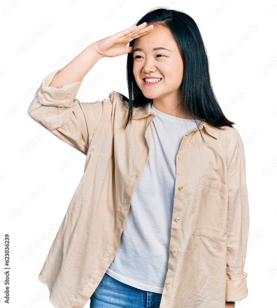 Young chinese woman wearing casual white t shirt and jacket very happy and smiling looking far away with hand over head. searching concept. Young chinese woman wearing casual white t shirt and jacket very happy and smiling looking far away with hand over head. searching concept.