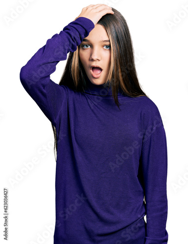 Young brunette girl with long hair wearing turtleneck sweater surprised with hand on head for mistake, remember error. forgot, bad memory concept. © Krakenimages.com