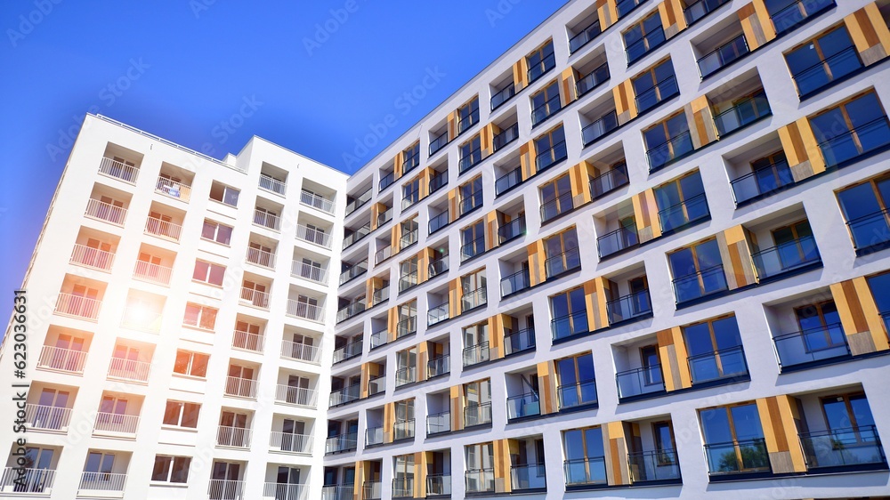 Fototapeta premium Contemporary residential building exterior in the daylight. Modern apartment buildings on a sunny day with a blue sky. Facade of a modern apartment building. 