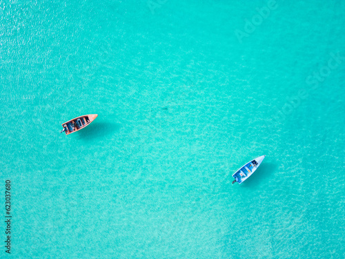 Aerial top view of two empty fishing boats moored on shallows in turquoise transparent Caribbean sea water. Minimalistic copy space tropical background © Bankerok