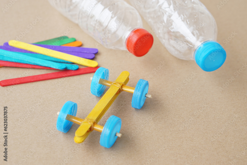 Handmade toy racing car made from ice cream sticks and bottle caps. Concept, Recycling kids toy. Easy to do, creative DIY craft that kids can do. Recycle invention. Handmade toy racing car made from ice cream sticks and bottle caps. Concept, Recycling kids toy. Easy to do, creative DIY craft that kids can do. Recycle invention.