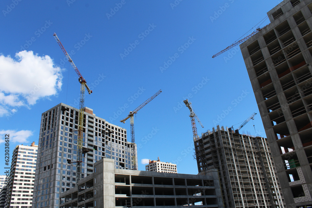 crane on a background of blue sky. construction of a crane and a crane on a background of multi - storey buildings.