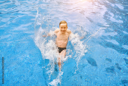 Child jump, swim in the pool, sunbathes, swimming in hot summer day. Relax, Travel, Holidays 