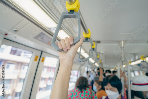Foto Woman hand firm grip safety handrail in elevated monorail train