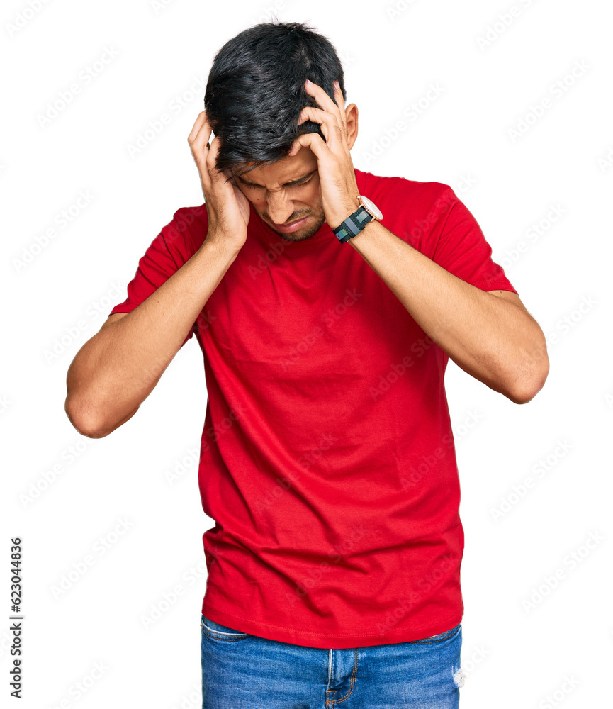 Young handsome man wearing casual red tshirt suffering from headache desperate and stressed because pain and migraine. hands on head. Young handsome man wearing casual red tshirt suffering from headache desperate and stressed because pain and migraine. hands on head.