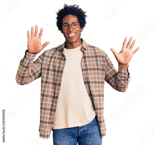 Handsome african american man with afro hair wearing casual clothes and glasses showing and pointing up with fingers number ten while smiling confident and happy.