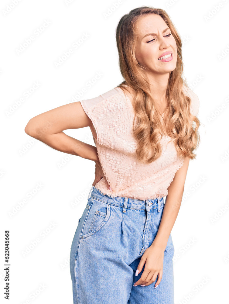Young beautiful caucasian woman with blond hair wearing casual clothes suffering of backache, touching back with hand, muscular pain Young beautiful caucasian woman with blond hair wearing casual clothes suffering of backache, touching back with hand, muscular pain