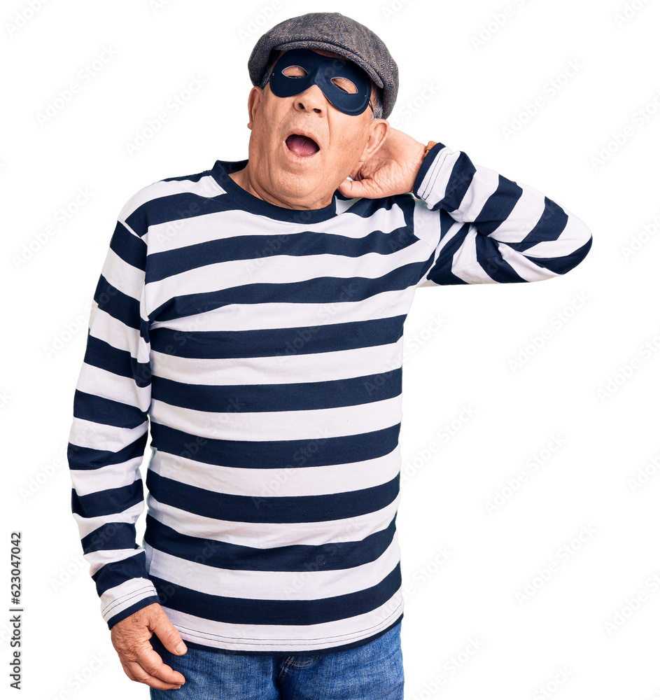Senior handsome man wearing burglar mask and t-shirt suffering of neck ache injury, touching neck with hand, muscular pain Senior handsome man wearing burglar mask and t-shirt suffering of neck ache injury, touching neck with hand, muscular pain