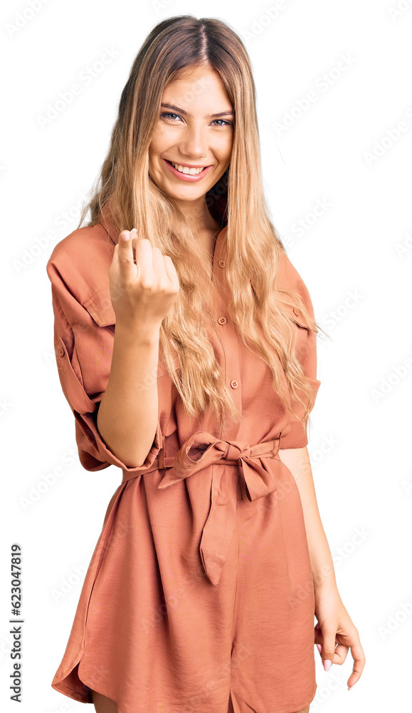 Beautiful caucasian woman with blonde hair wearing summer jumpsuit beckoning come here gesture with hand inviting welcoming happy and smiling Beautiful caucasian woman with blonde hair wearing summer jumpsuit beckoning come here gesture with hand inviting welcoming happy and smiling