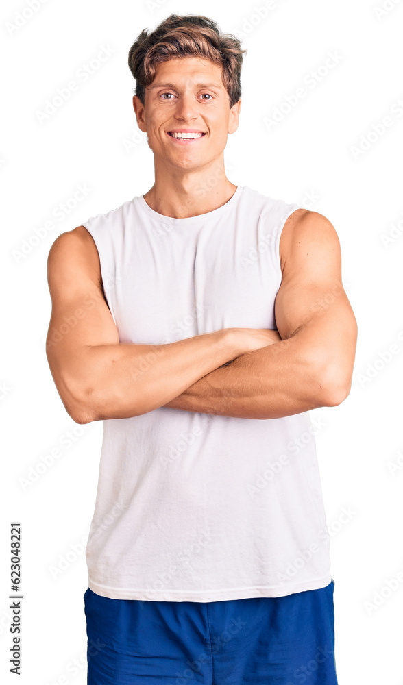 Young handsome man wearing sleveeless t shirt happy face smiling with crossed arms looking at the camera. positive person. Young handsome man wearing sleveeless t shirt happy face smiling with crossed arms looking at the camera. positive person.