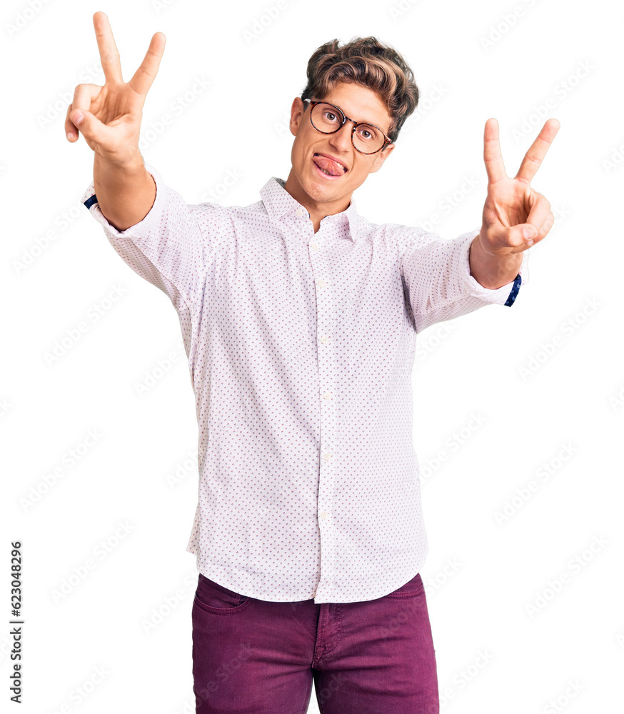 Young handsome man wearing business clothes and glasses smiling with tongue out showing fingers of both hands doing victory sign. number two. Young handsome man wearing business clothes and glasses smiling with tongue out showing fingers of both hands doing victory sign. number two.