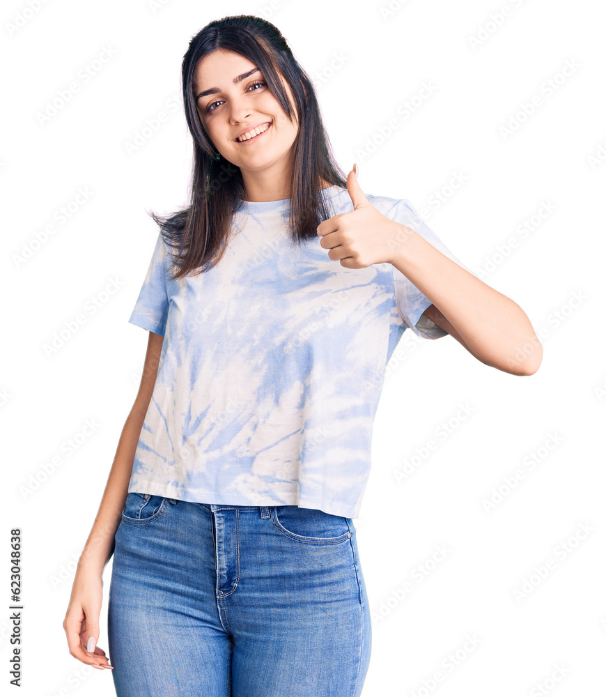 Young beautiful girl wearing casual t shirt doing happy thumbs up gesture with hand. approving expression looking at the camera showing success.
