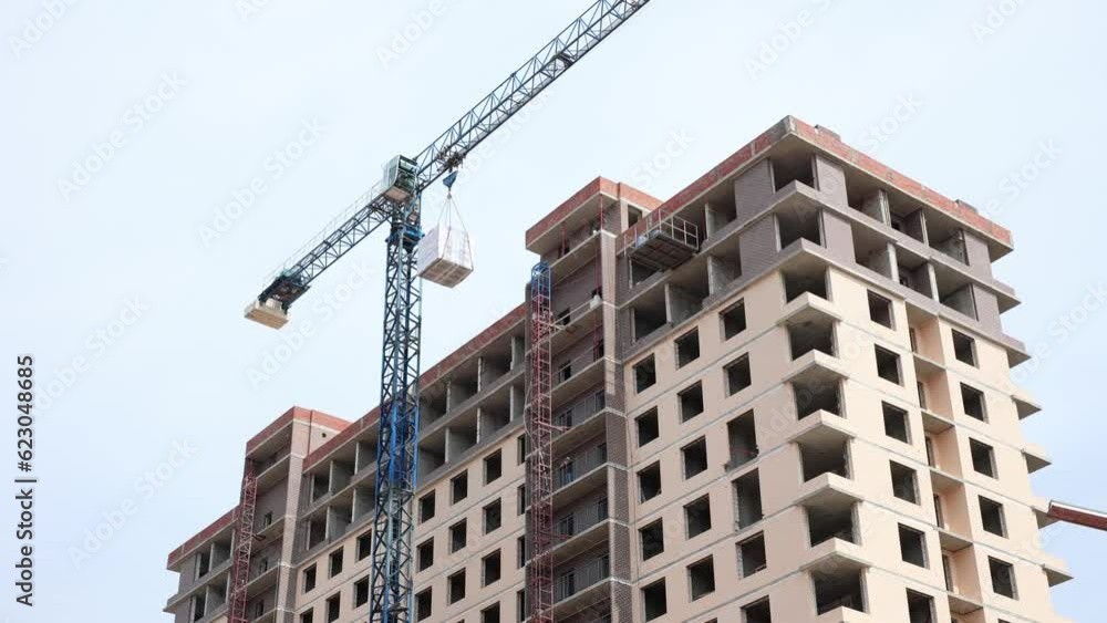 Construction site of multi-storey buildings. Cranes lift building blocks Construction site of multi-storey buildings. Cranes lift building blocks
