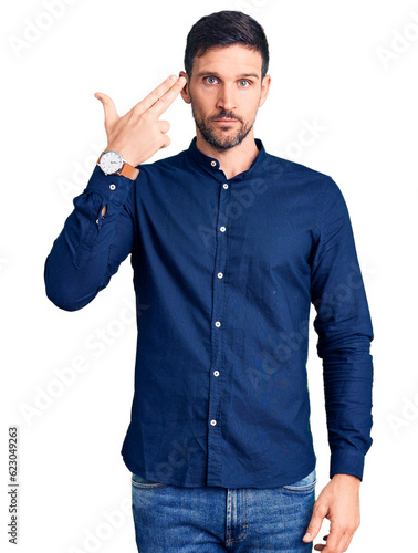 Photography Young handsome man wearing casual shirt shooting and killing oneself pointing hand and fingers to head like gun, suicide gesture