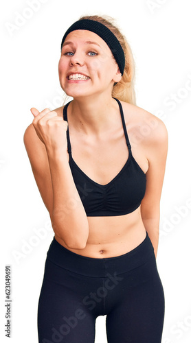Young beautiful blonde woman wearing sportswear angry and mad raising fist frustrated and furious while shouting with anger. rage and aggressive concept.