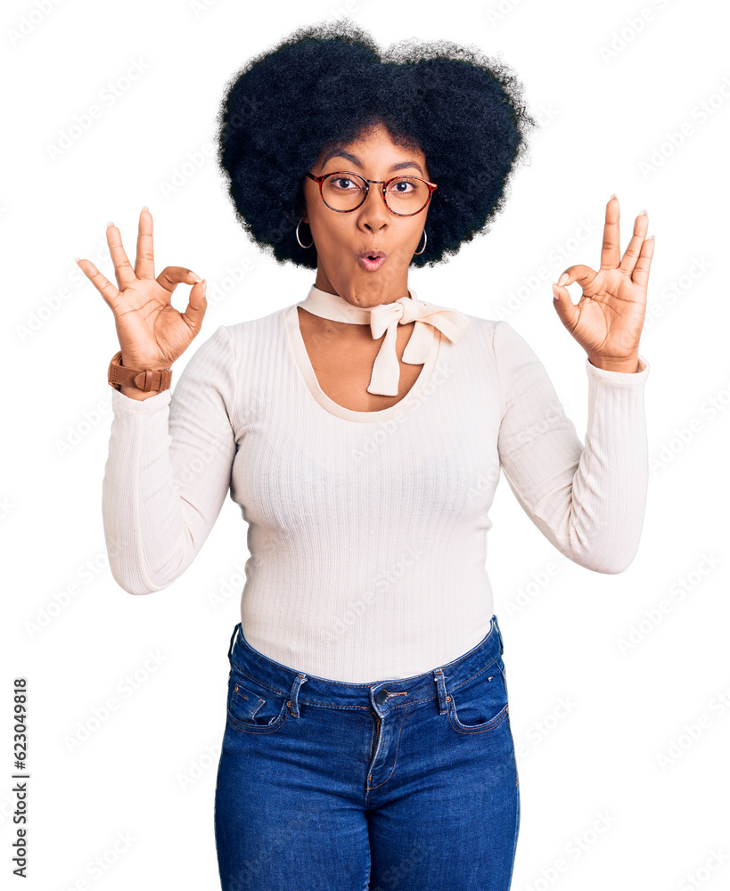 Young african american girl wearing casual clothes and glasses looking surprised and shocked doing ok approval symbol with fingers. crazy expression Young african american girl wearing casual clothes and glasses looking surprised and shocked doing ok approval symbol with fingers. crazy expression