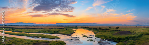 sunset over the river, moutains and grass with cloud in the sky © Yi_Studio