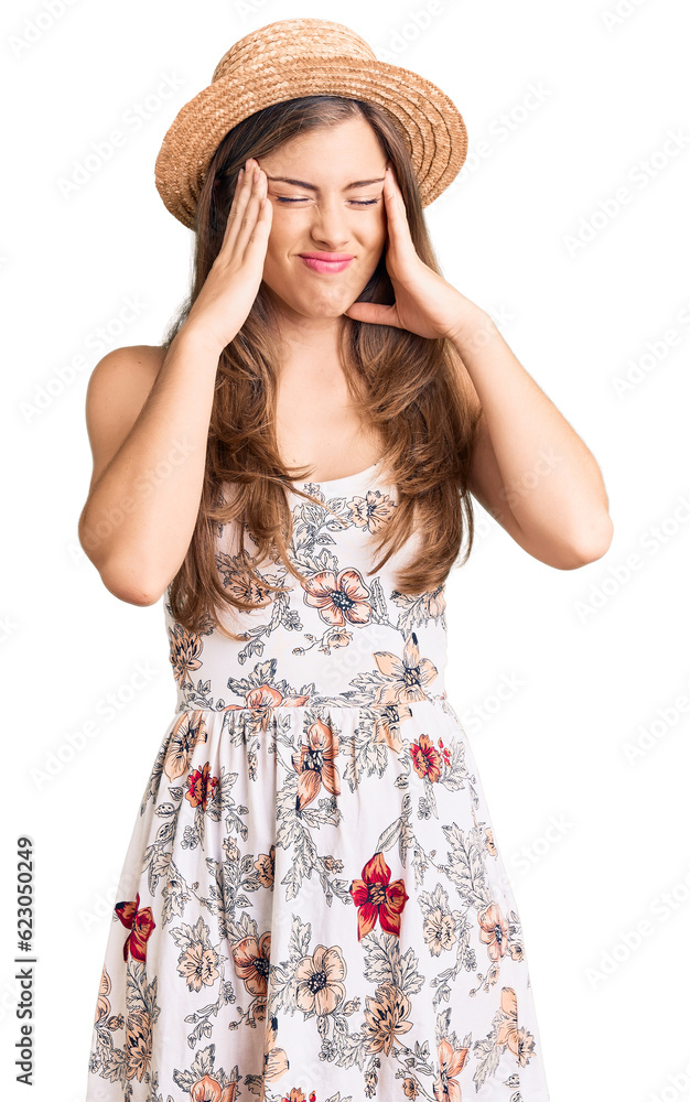 Beautiful caucasian young woman wearing summer hat with hand on head for pain in head because stress. suffering migraine. Beautiful caucasian young woman wearing summer hat with hand on head for pain in head because stress. suffering migraine.