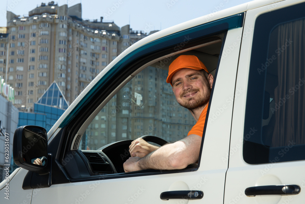 A smiling courier carries parcels by car