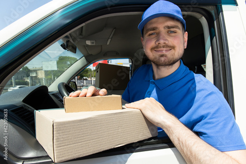 A smiling courier delivers parcels by car